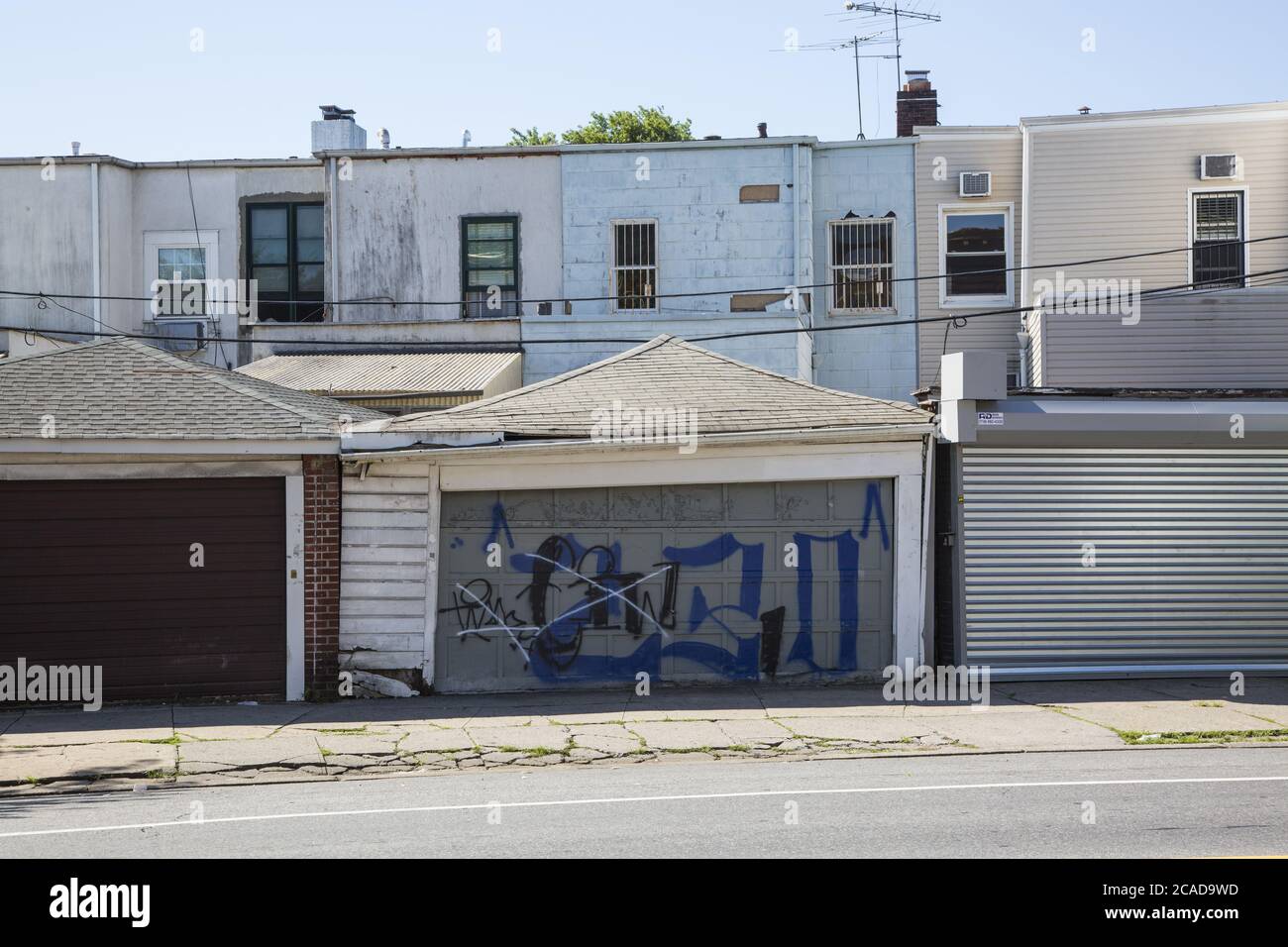 Vecchi garage e il retro di case a basso costo costruito vecchi edifici lungo Church Avenue nel quartiere multirazziale di Kensington a Brooklyn, New York. Foto Stock
