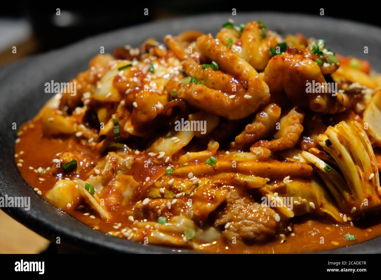 Primo piano Octopus e maiale sottaceto in pentola nera. Popolare cucina coreana. Sfocatura dello sfondo Foto Stock