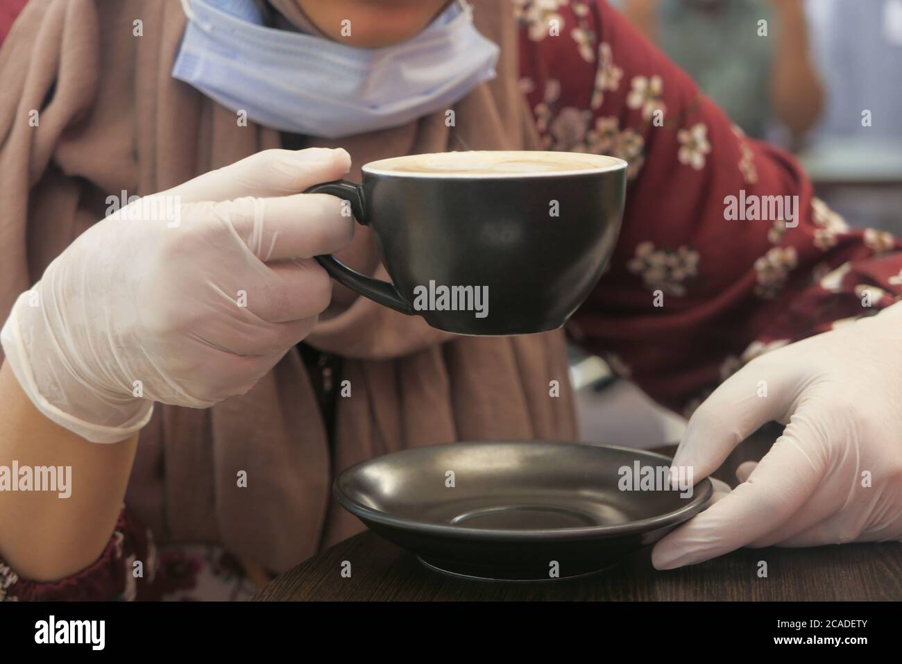 donne in guanti medici bere caffè al caffè. Foto Stock