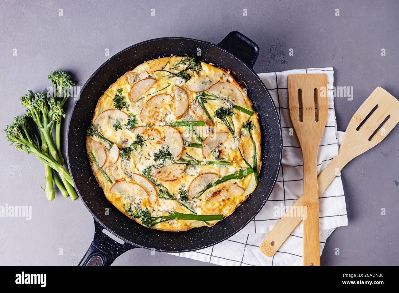 Frittata di uova al forno con formaggio e broccolini su tavola grigia Foto Stock