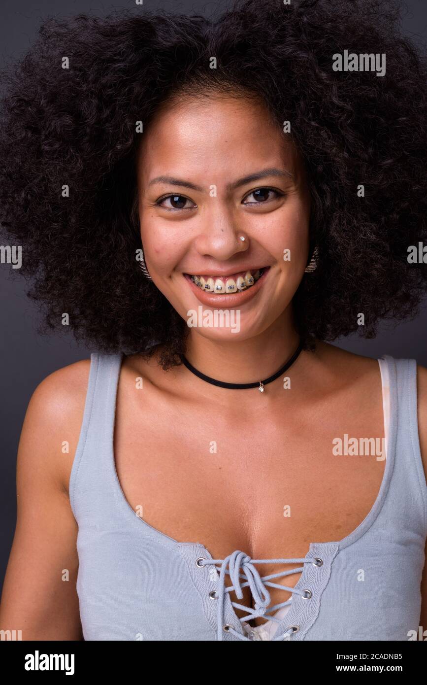 Felice giovane bella donna africana con capelli afro Foto Stock