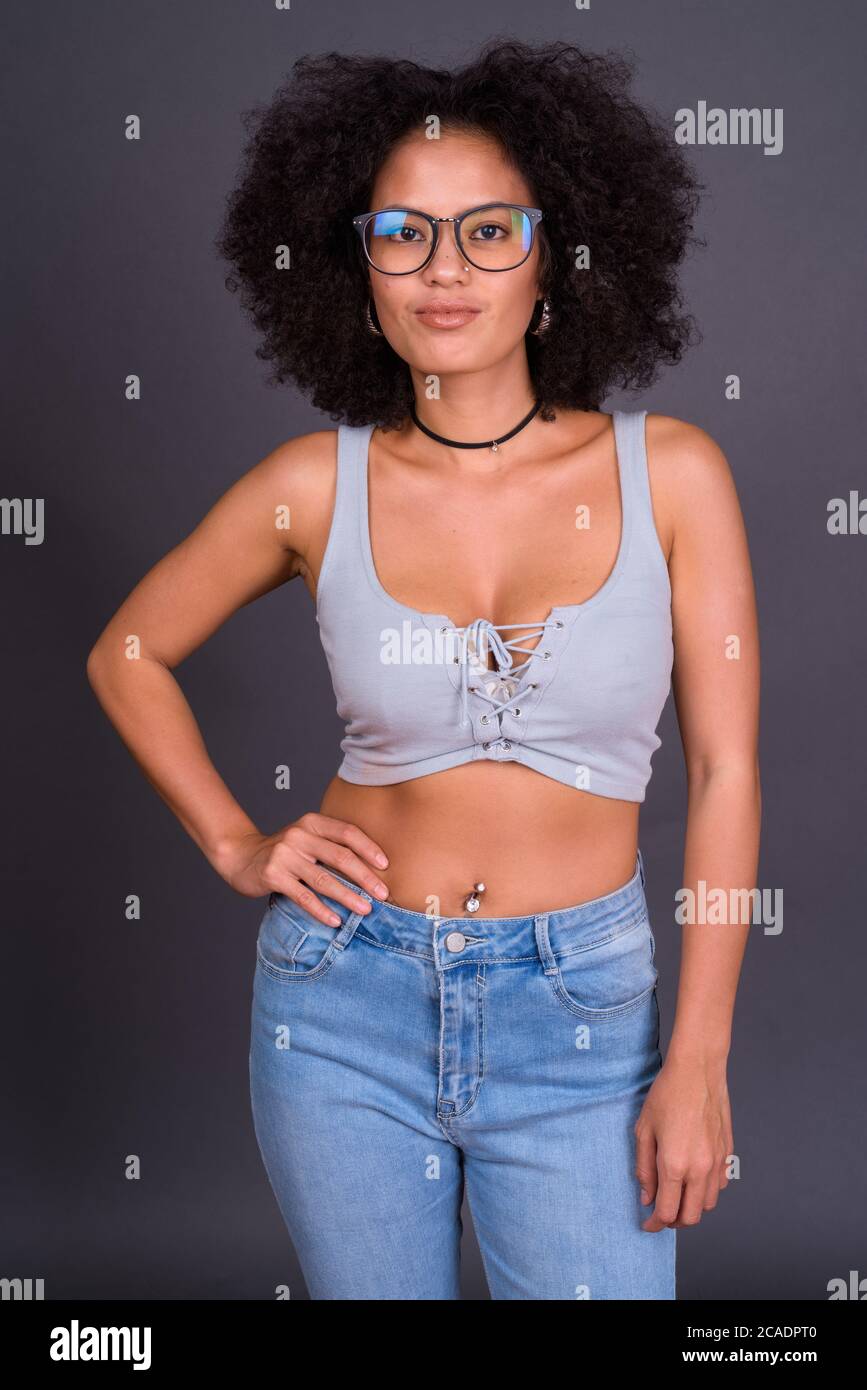 Giovane bella donna africana con capelli afro che indossano occhiali Foto Stock