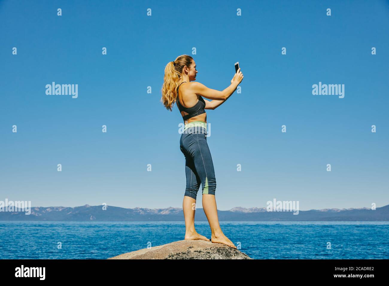 Giovane donna scattando una foto del lago Tahoe. Foto Stock