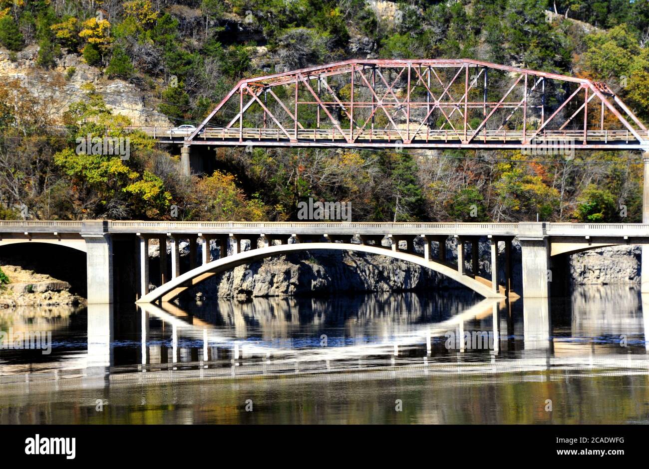 Due ponti attraversano il lago Bull Shoals. Uno è un ponte in acciaio più vecchio e l'altro una struttura in cemento. Il ponte inferiore si riflette nell'acqua. Foto Stock