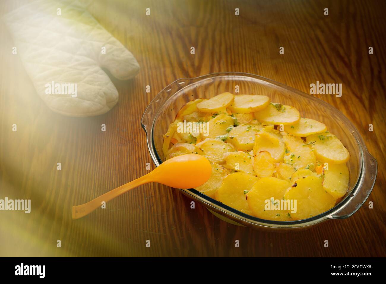 Deliziosa moussaka servita sul bancone della cucina con guanto da cucina sullo sfondo Foto Stock