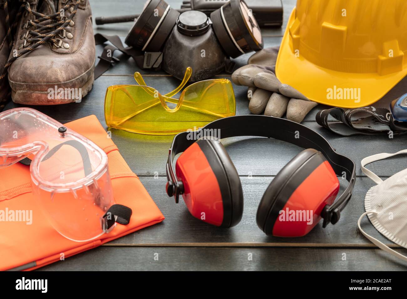 Attrezzatura di protezione per la sicurezza sul lavoro. Dispositivi di protezione industriale su fondo tavolo in legno, vista closeup. Concetto di salute e sicurezza del cantiere Foto Stock