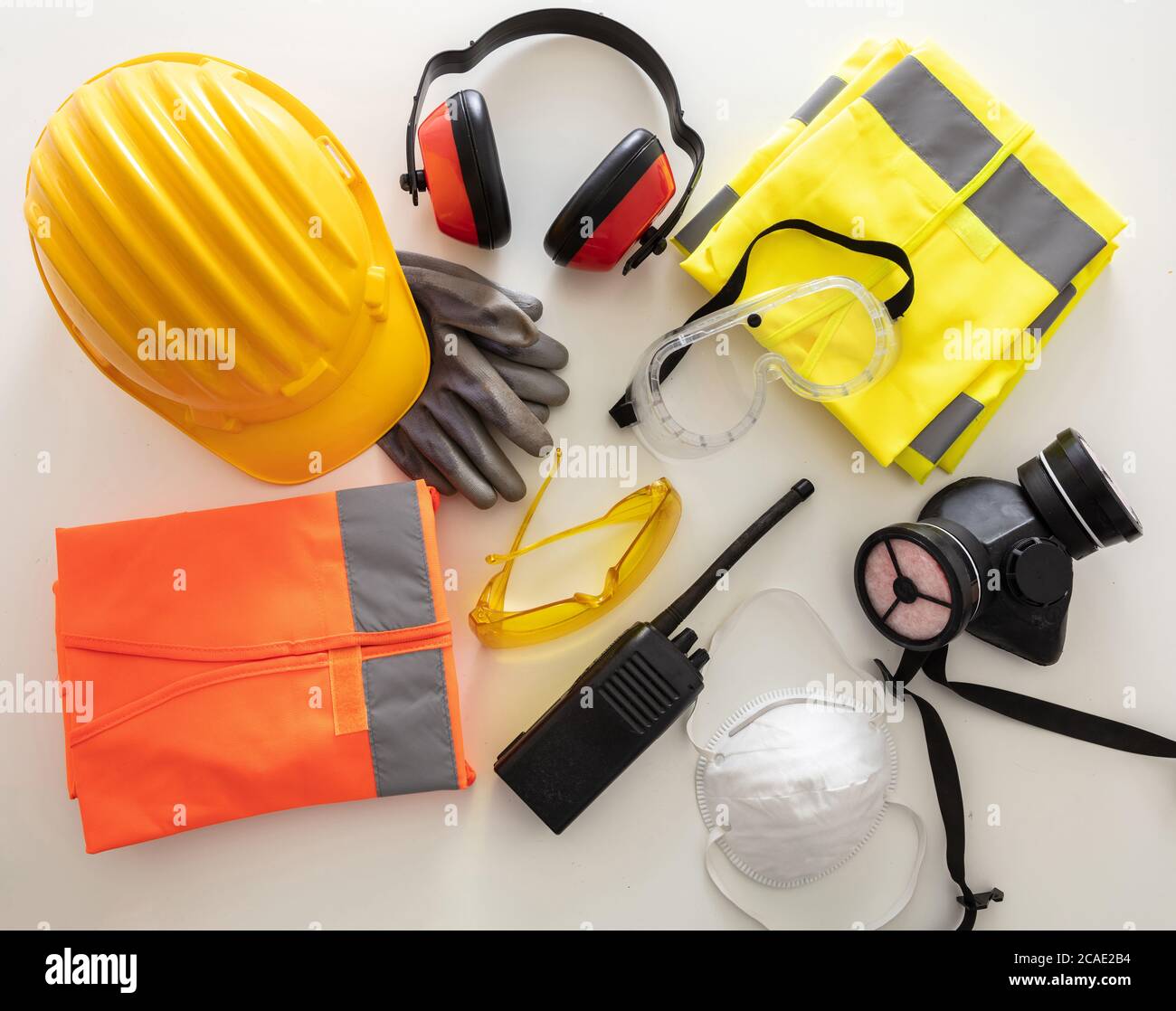Attrezzatura di protezione per la sicurezza sul lavoro in piano. Dispositivi di protezione industriale su sfondo bianco, vista dall'alto. Concetto di salute e sicurezza del cantiere Foto Stock
