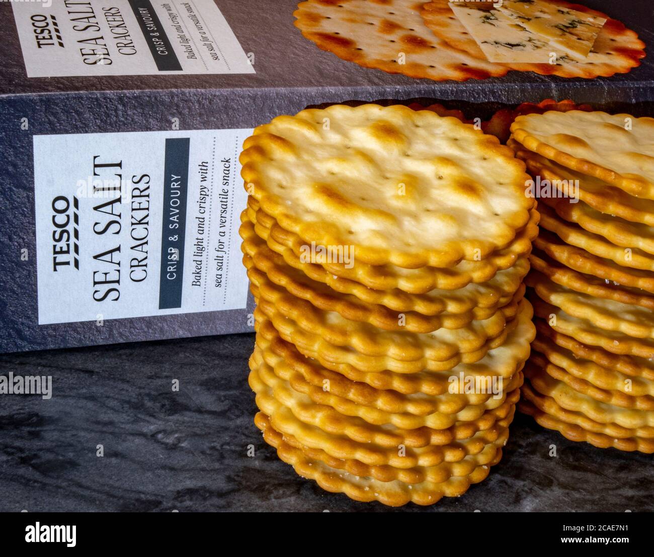 Tesco cracker di sale marino, croccanti e salati, impilati davanti alla confezione del prodotto. Foto Stock