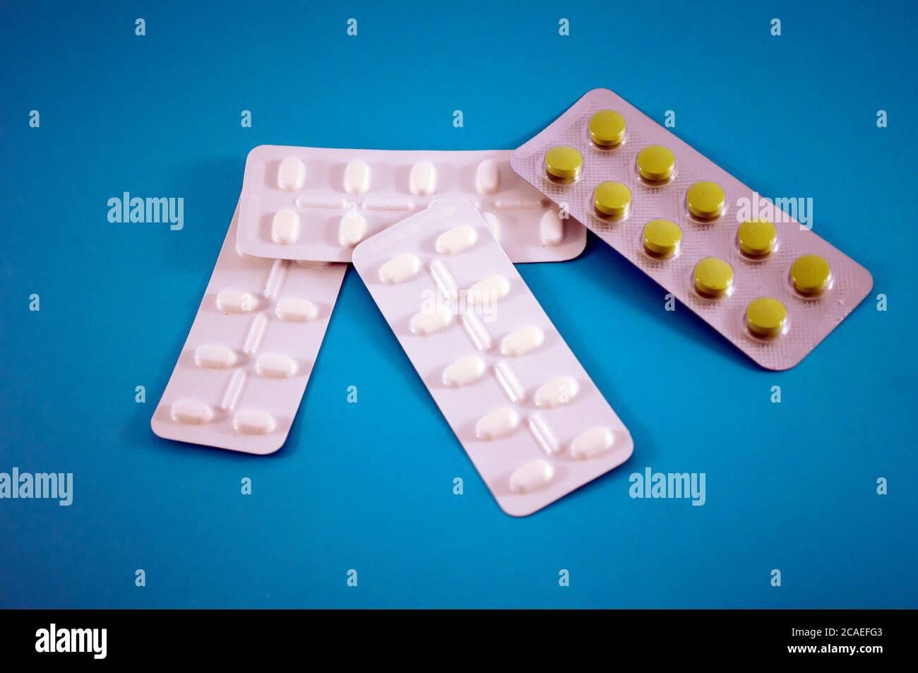 Blister di pillole, vitamine, compresse, medicinali su sfondo blu Foto Stock