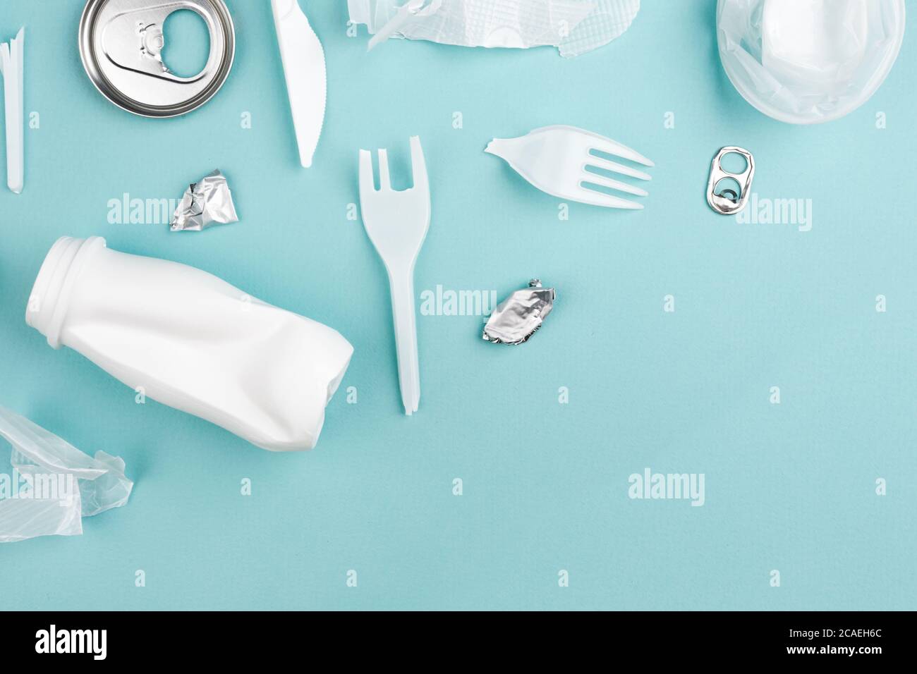 Rifiuti di plastica diversi su sfondo blu. Concetto di riciclaggio dei rifiuti in plastica. Ecologia e cura ambientale. Foto Stock