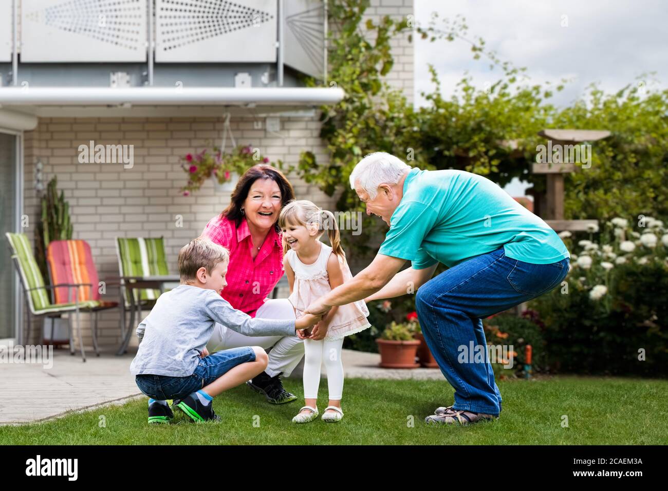 Felice coppia di nonni vecchi divertirsi con i nipoti Foto Stock