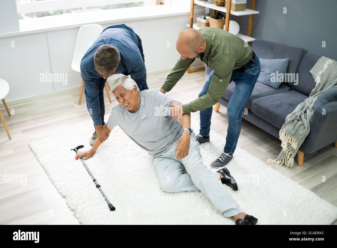 Aiutare l'anziano anziano caduto uomo dopo l'incidente di caduta Foto Stock