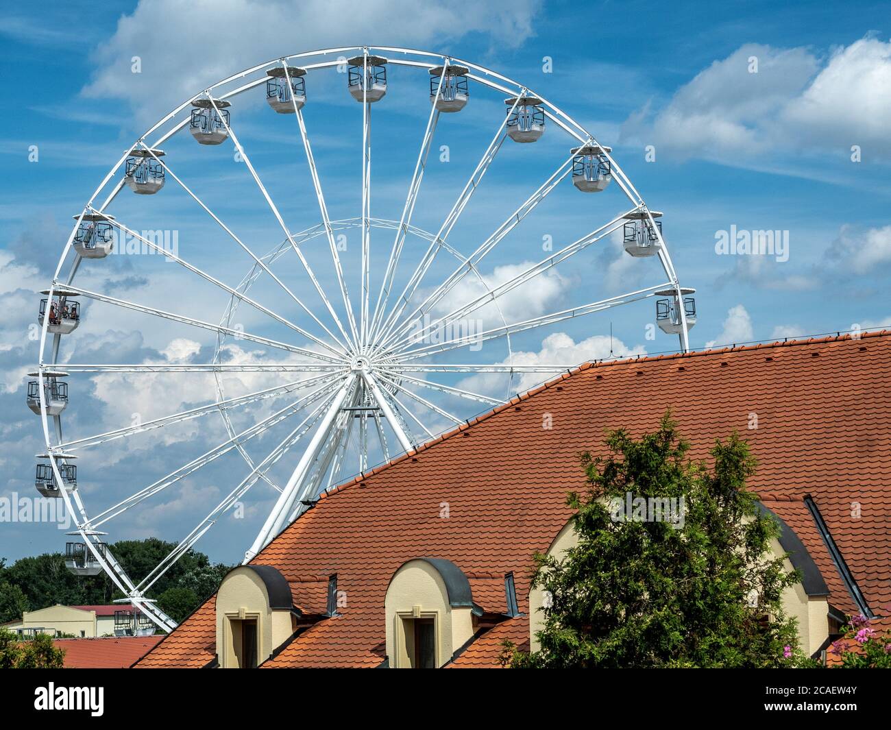 Repubblica Ceca, Zajeci - 20 luglio 2020. Ruota di ferro bianca sopra i tetti rossi del villaggio di Zajeci. Foto Stock