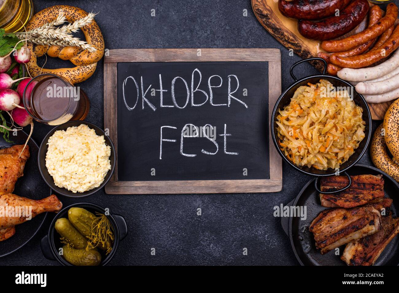 Piatti Oktoberfest con birra, pretzel e salsiccia Foto Stock