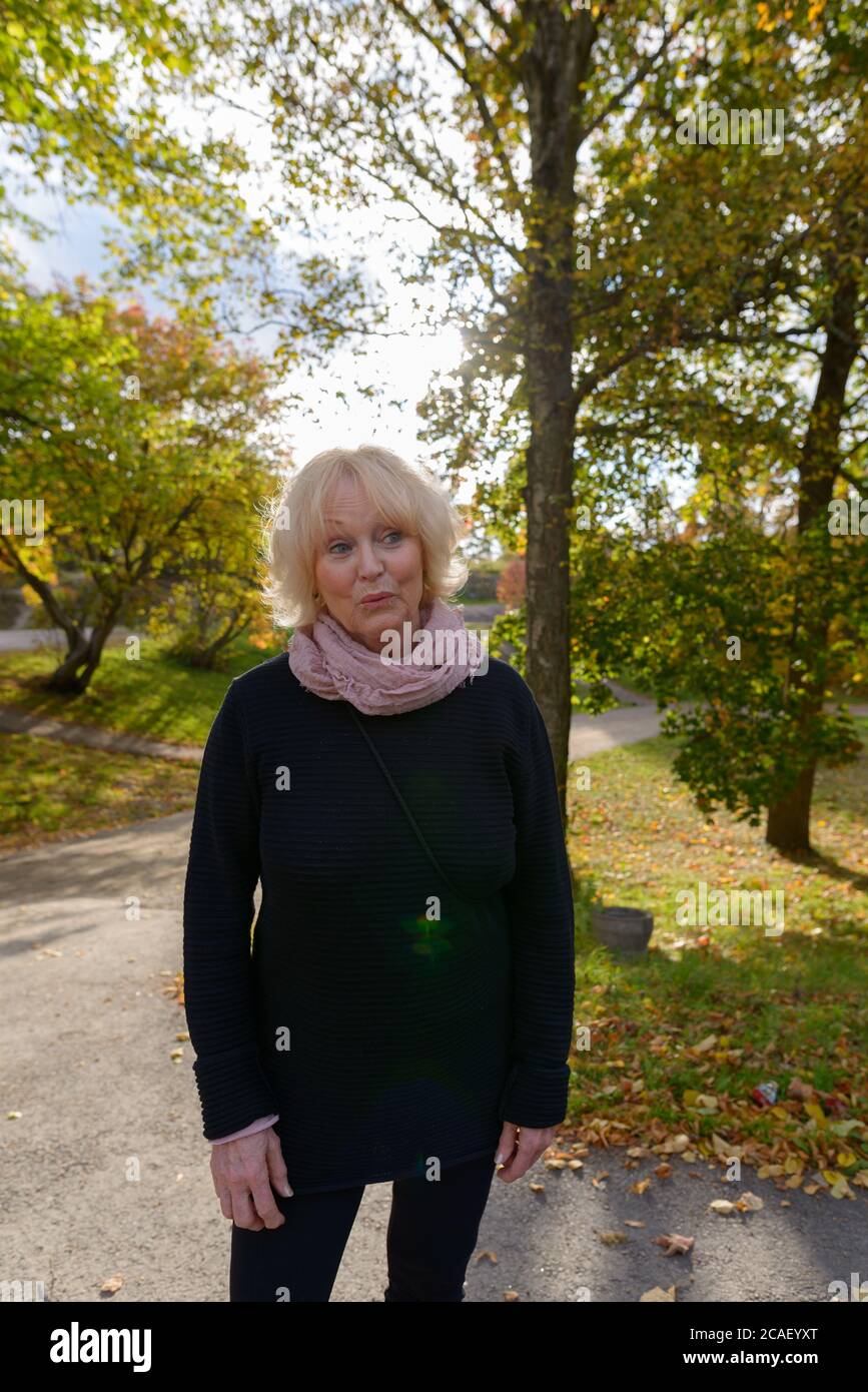 Donna anziana sul sentiero di tranquillo e rilassante parco naturale Foto Stock