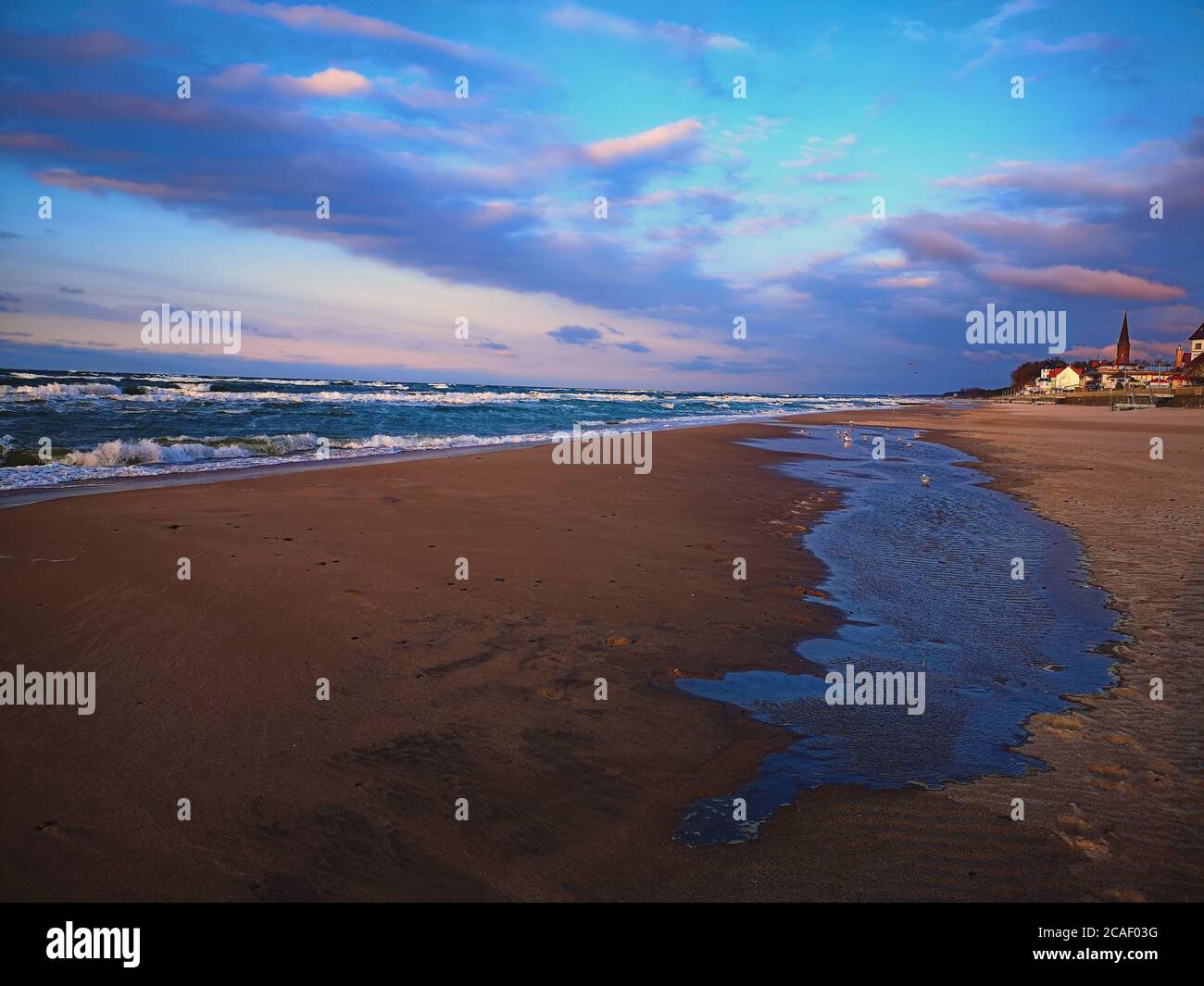 Una vista mozzafiato che si affaccia su una delle spiagge sabbiose della Polonia, con un laghetto temporaneo sparso sulla sabbia del Baltico. Foto Stock