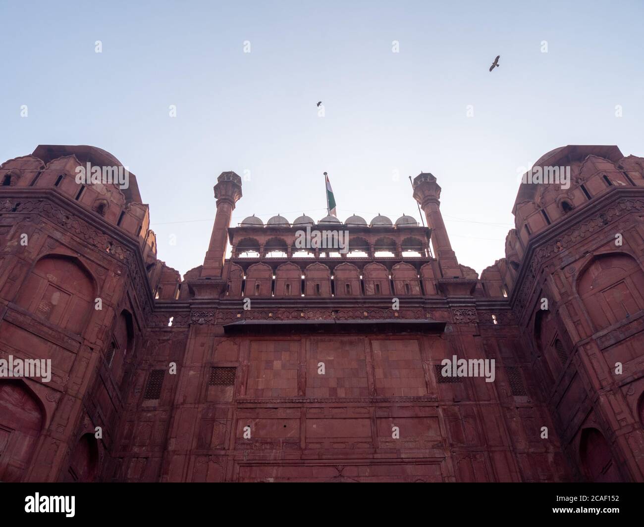 una vista ad angolo basso della bandiera indiana che vola sopra il cancello di lahori al forte rosso nella vecchia delhi Foto Stock