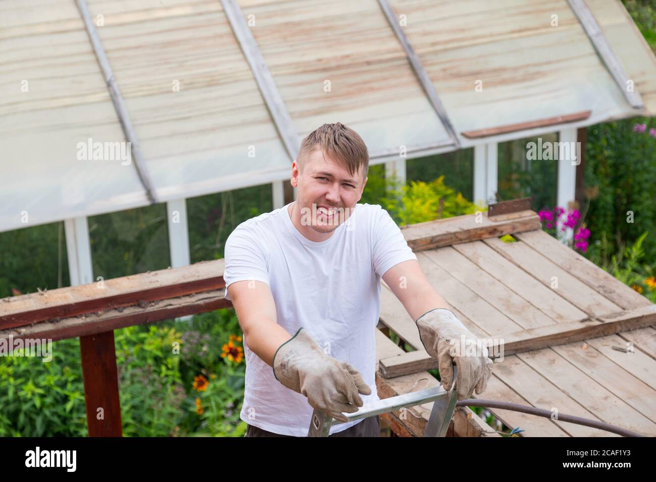 Un uomo si alza sulle scale, riposandosi e sorridendo alla telecamera Foto Stock