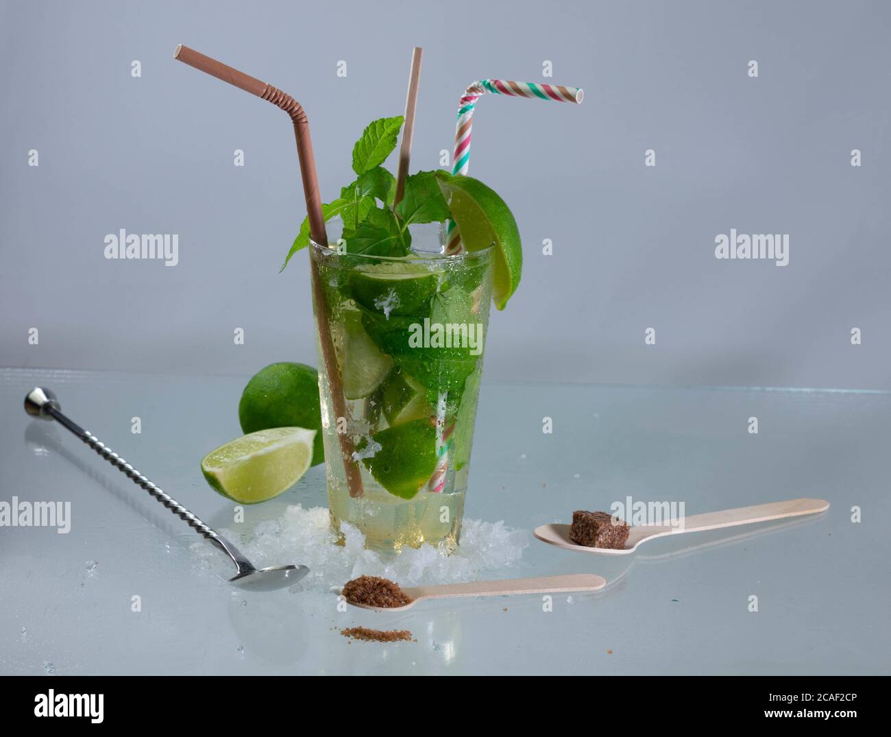 Cocktail Mojito con rum, lime e foglie di menta su una superficie grigia Foto Stock