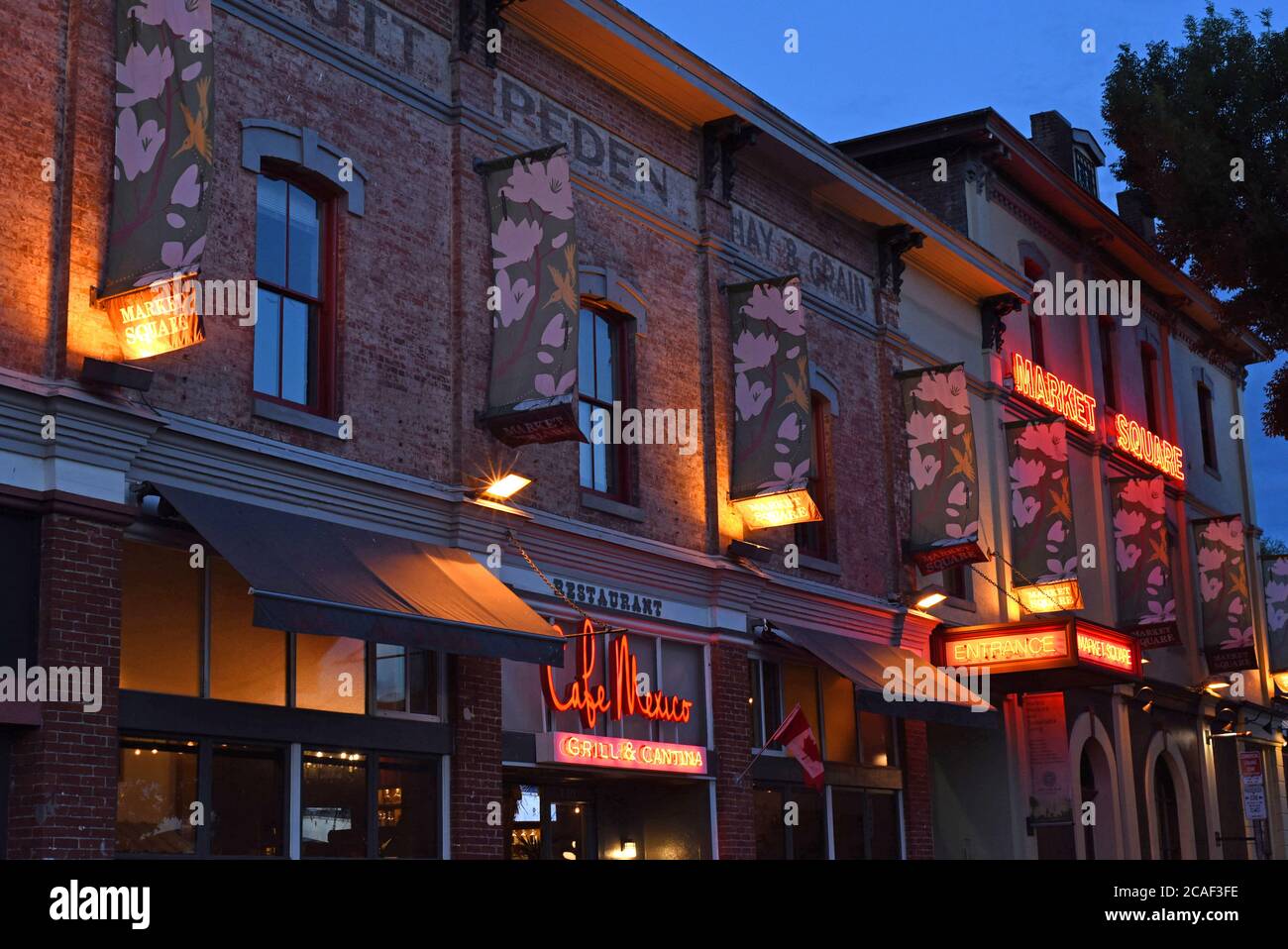 Una vista esterna del popolare ristorante e complesso commerciale Market Square a Victoria, British Columbia, Canada sull'isola di Vancouver di notte con l Foto Stock