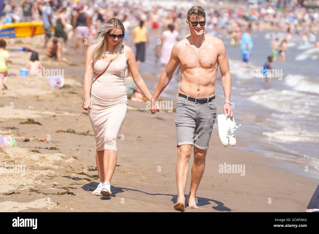 Scarborough, Regno Unito. 31 luglio 2020. Una coppia fa una passeggiata a South Bay Beach, East Yorkshire durante la stagione calda. Il Regno Unito è impostato per crogiolarsi come le temperature raggiungeranno 36 gradi Celsius nella capitale durante una mini onda di calore. Credit: Yiannis Alexopoulos/SOPA Images/ZUMA Wire/Alamy Live News Foto Stock