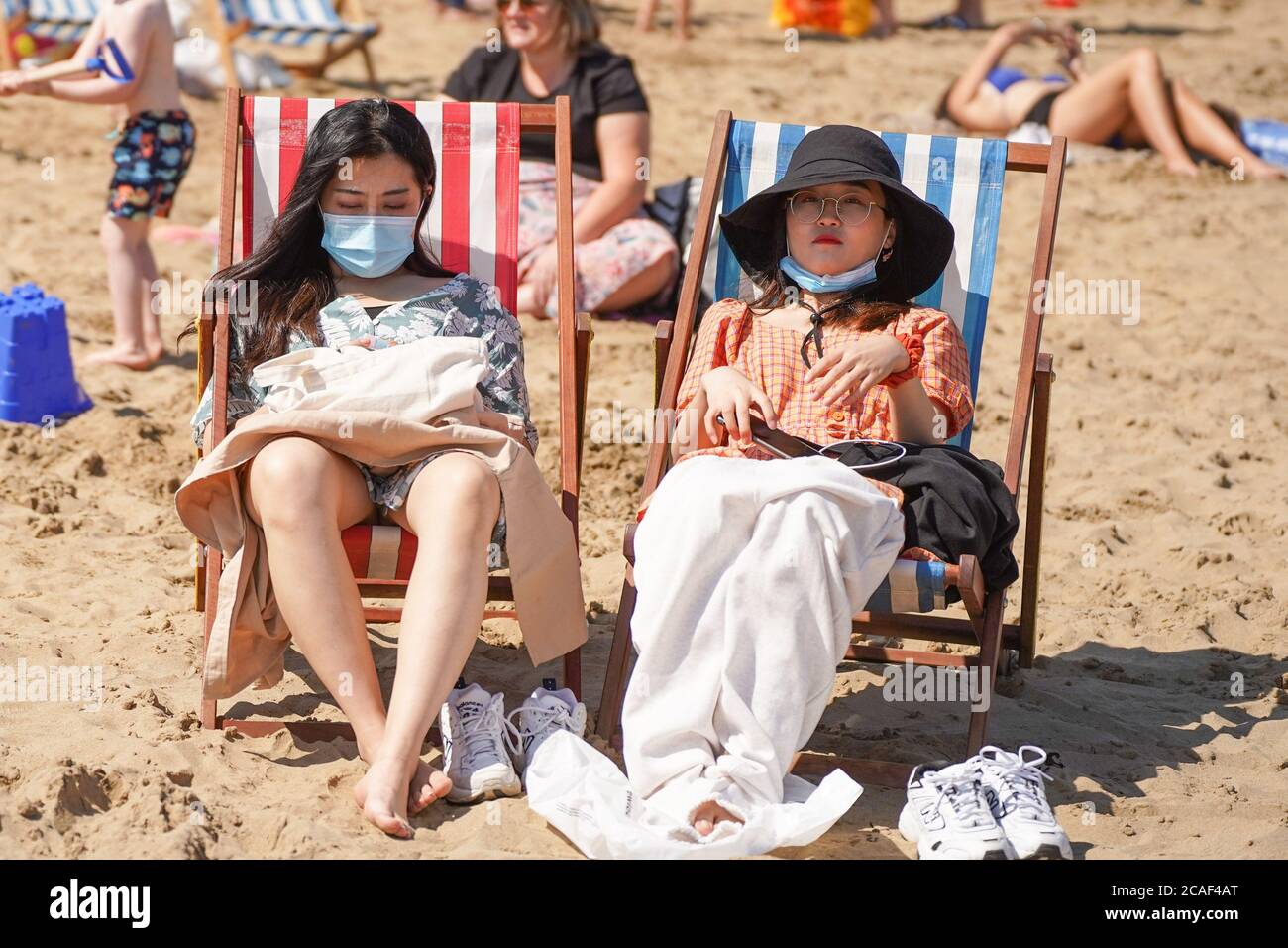 Scarborough, Regno Unito. 31 luglio 2020. I bagnanti che indossano maschere mentre si siedono sulle sedie a sdraio a South Bay Beach durante il tempo caldo. Il Regno Unito è impostato per crogiolarsi come le temperature raggiungeranno 36 gradi Celsius nella capitale durante una mini onda di calore. Credit: Yiannis Alexopoulos/SOPA Images/ZUMA Wire/Alamy Live News Foto Stock