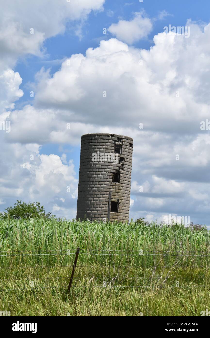 Old Brick Grain Silo in un campo Foto Stock