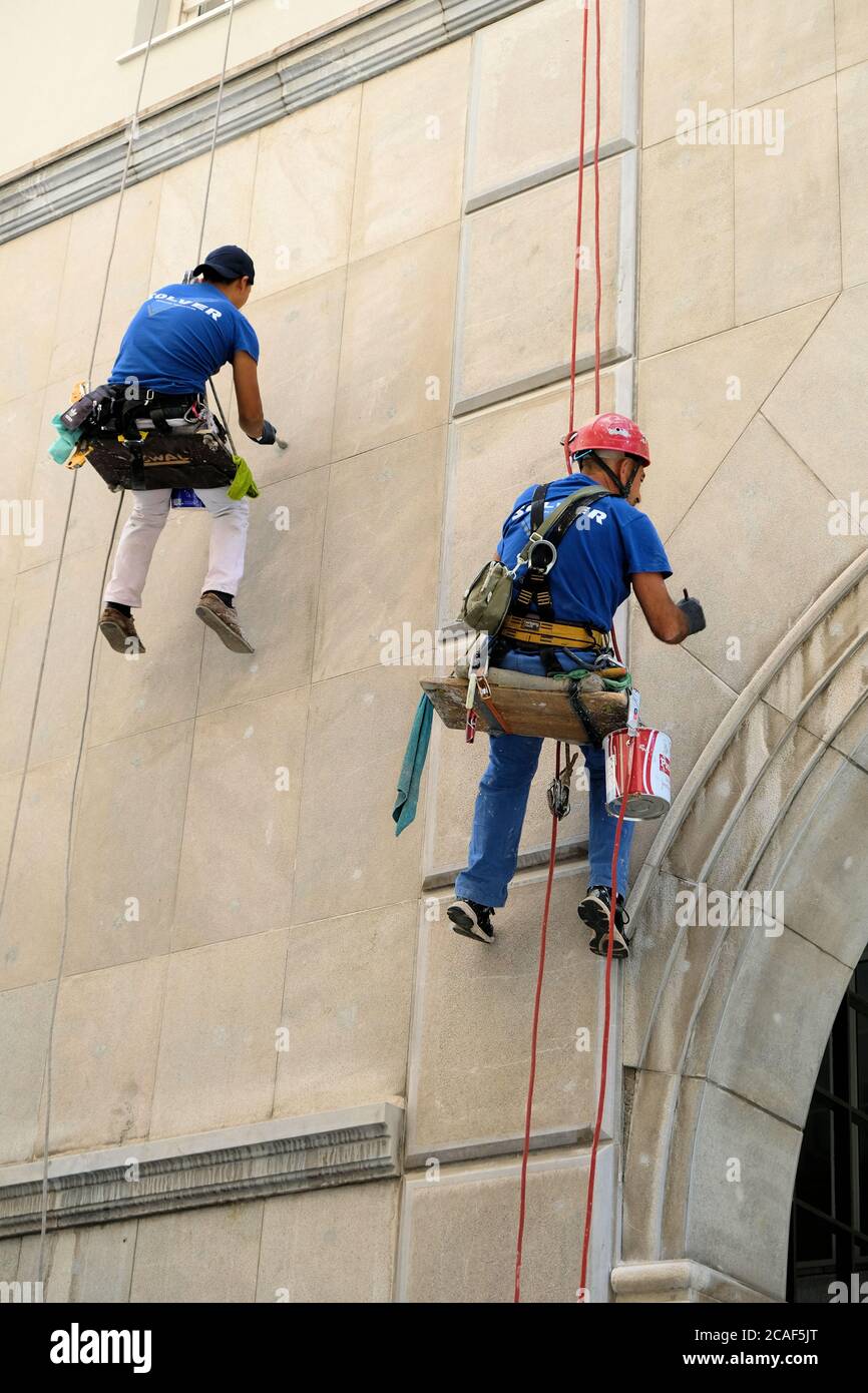 Due lavoratori verticali impiegati da Solver Soluciones verticales appesi su funi da arrampicata ristrutturando una facciata o l'esterno di un edificio a Granada, Spagna. Foto Stock