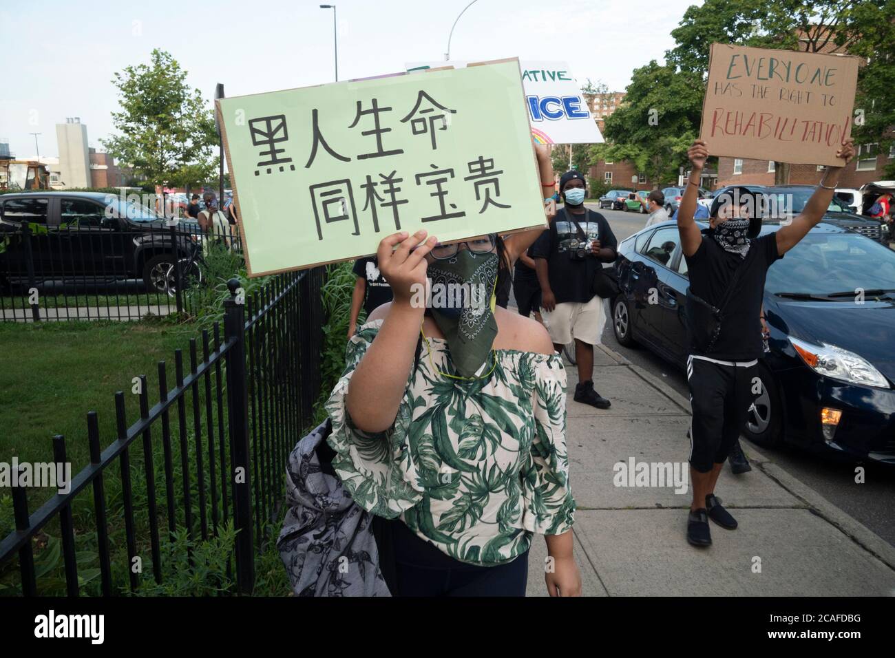Queens, New York, Stati Uniti. 6 agosto 2020. Un dimostratore tiene una questione Black Lives sospiro in mandarino durante una questione Black Lives, la gente marcia contro i manifestanti vicino all'hotel Wyndham nel quartiere Fresh Meadows nel Queens Borough di New York, New York. I manifestanti della gente di marzo hanno sostenuto un altro gruppo dimostrativo chiamato Esodo che stava sostenendo i formalmente incarcerati che hanno alloggi temporanei presso l'hotel. I vicini e i dimostranti della comunità di Fresh Meadows si oppongono ai nuovi detenuti rilasciati. Credit: ZUMA Press, Inc./Alamy Live News Foto Stock