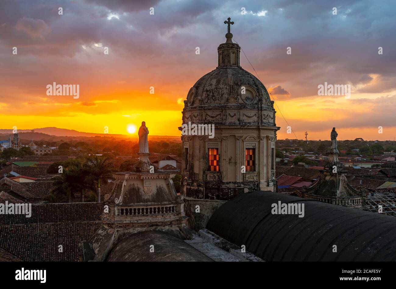 Cupola della chiesa la Merced a Granada al tramonto con sculture della Vergine Maria e lo skyline della città, Nicaragua. Foto Stock