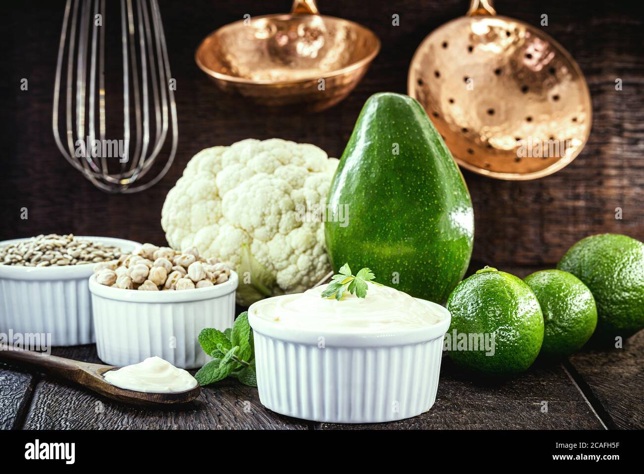 maionese vegana, foto concettuale, maionese a base di verdure senza uova o latte. Crema di avocado, ceci, limone, cavolo e semi di girasole. Foto Stock