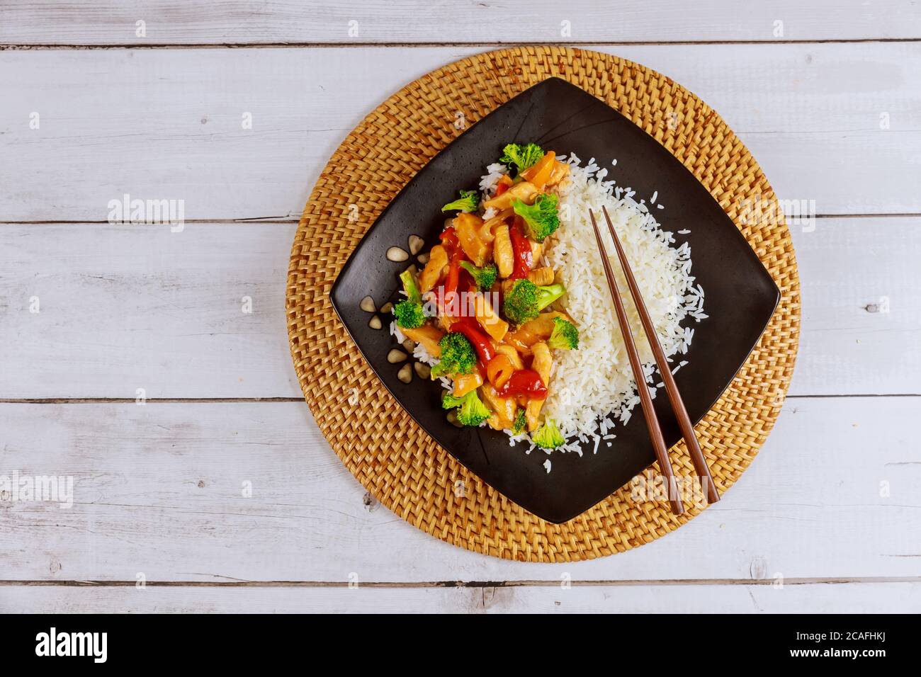 Riso con pollo e verdure fritte in padella nera con bastone. Foto Stock