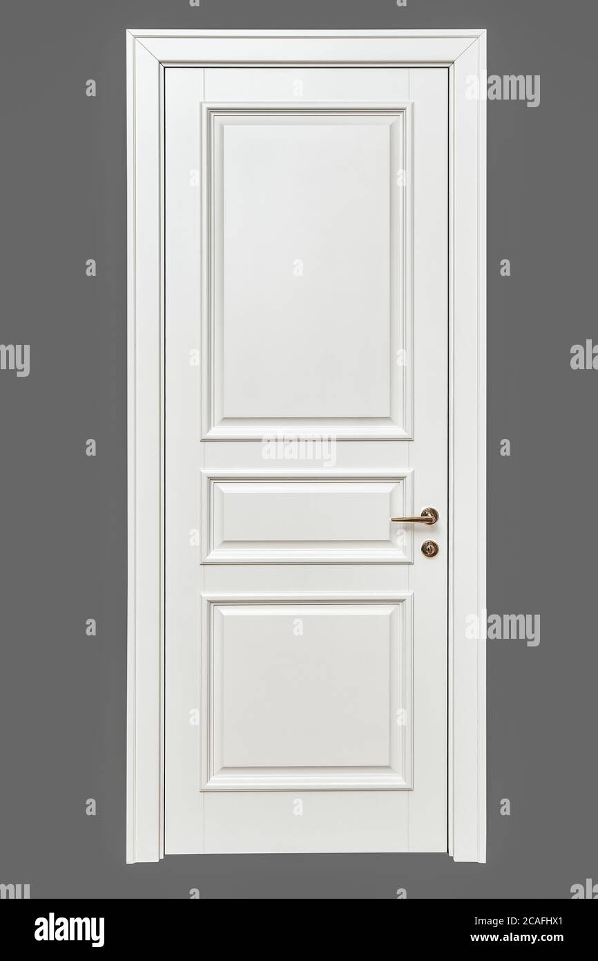 Porta bianca in stile classico. Porta interna bianca con maniglia dorata isolata su sfondo grigio. Produzione di mobili. Foto Stock