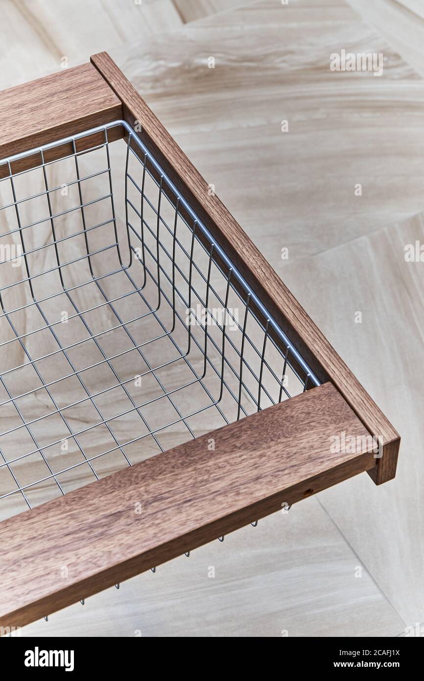 Organizzazione dello storage. Cestello in rete metallica in cassetto di legno nel deposito di cibo. Primo piano Foto Stock