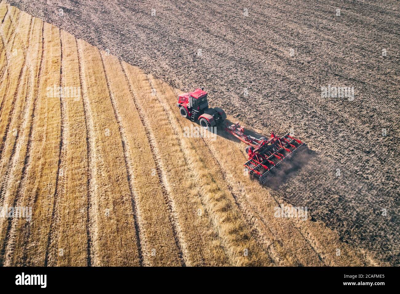Trattore che lavora nei campi, Vista aerea, Hay sul campo. La vista dall'alto. Il trattore raccoglie l'erba secca. Foto Stock