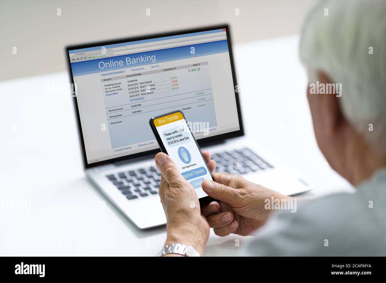 Senior che utilizza l'app di autenticazione online a due fattori Foto Stock