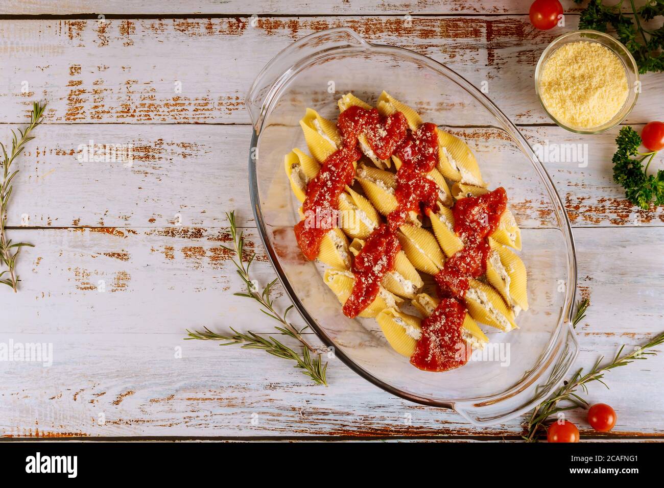 Conchiglie farcite con parmigiano, salsa di pomodoro e ricotta cotte in teglia da forno. Foto Stock