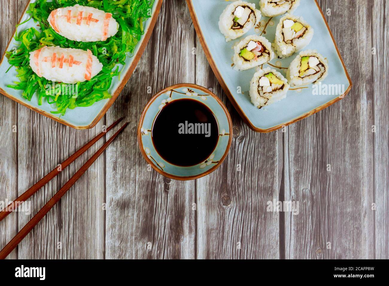 Delizioso sushi e panini con salsa di soia e chopstick per la festa di football americano per i tifosi. Foto Stock