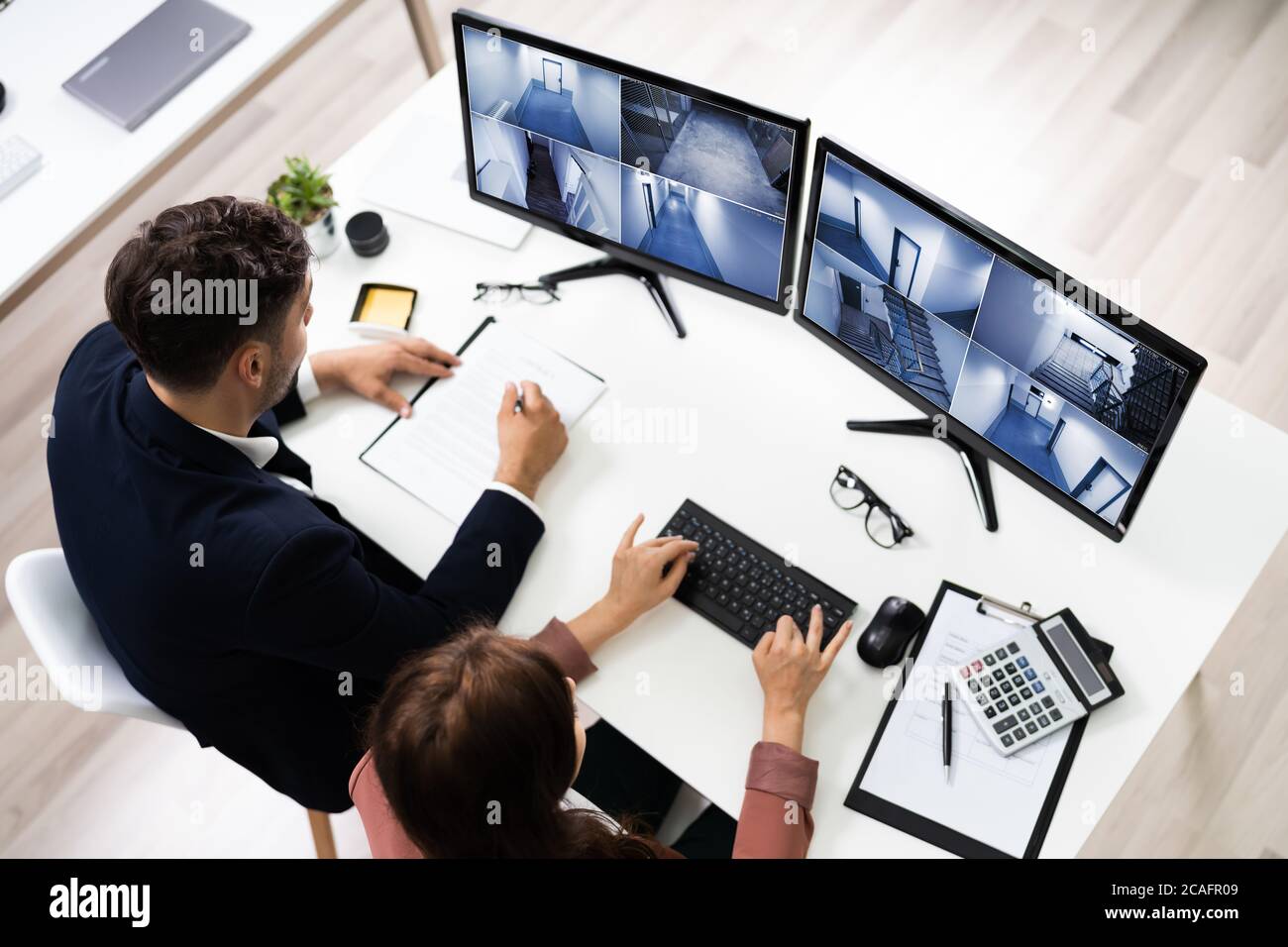 Riprese TVCC controllo di sicurezza operatori che guardano le riprese di sorveglianza sul computer Foto Stock