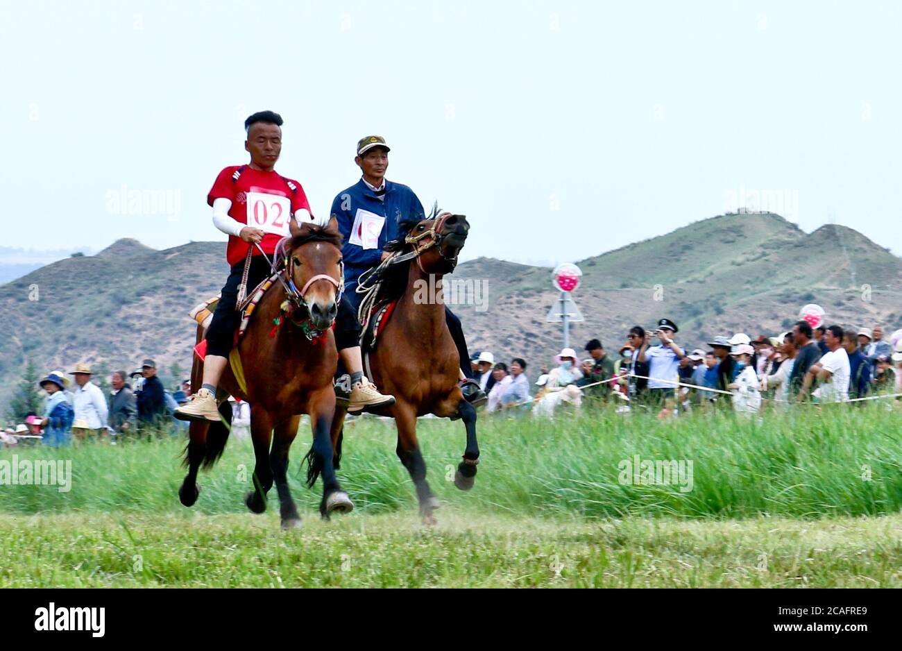 Zhangye, Zhangye, Cina. 7 agosto 2020. GansuÃ¯Â¼Å CINA-herders e cavalieri galoppo sulla prateria in Horseshoe Tibetan Township nella contea autonoma di Sunan Yugur di Zhangye City, nella provincia di Gansu della Cina nord-occidentale, 4 agosto 2020. Più di 3,000 turisti da Qinghai, Xinjiang e contee e città vicine sono attratti per vedere il project.on quel giorno, Più di 60 Riders dei gruppi etnici tibetani e Yugu hanno tenuto una corsa tradizionale sulle corse dei cavalli al Festival delle corse dei cavalli della città tibetana di Horseshoe nella contea autonoma di Sunan Yugu, nella città di Zhangye, nella provincia di Gansu. Si trova presso il Foto Stock