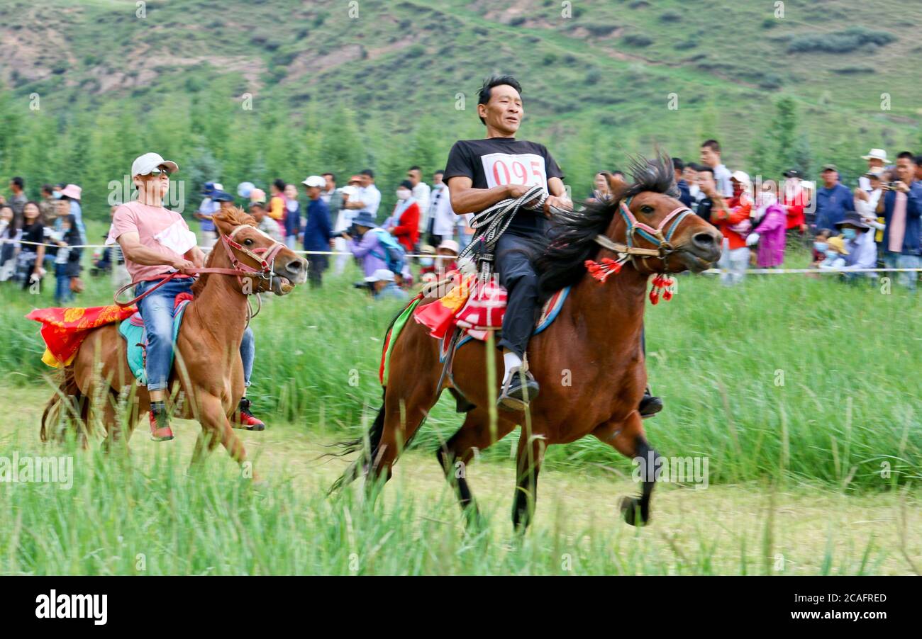 Zhangye, Zhangye, Cina. 7 agosto 2020. GansuÃ¯Â¼Å CINA-herders e cavalieri galoppo sulla prateria in Horseshoe Tibetan Township nella contea autonoma di Sunan Yugur di Zhangye City, nella provincia di Gansu della Cina nord-occidentale, 4 agosto 2020. Più di 3,000 turisti da Qinghai, Xinjiang e contee e città vicine sono attratti per vedere il project.on quel giorno, Più di 60 Riders dei gruppi etnici tibetani e Yugu hanno tenuto una corsa tradizionale sulle corse dei cavalli al Festival delle corse dei cavalli della città tibetana di Horseshoe nella contea autonoma di Sunan Yugu, nella città di Zhangye, nella provincia di Gansu. Si trova presso il Foto Stock