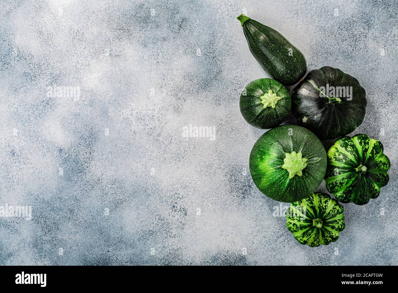 Verde Estate squash su sfondo di cemento lavato con copyspace, vista dall'alto Foto Stock