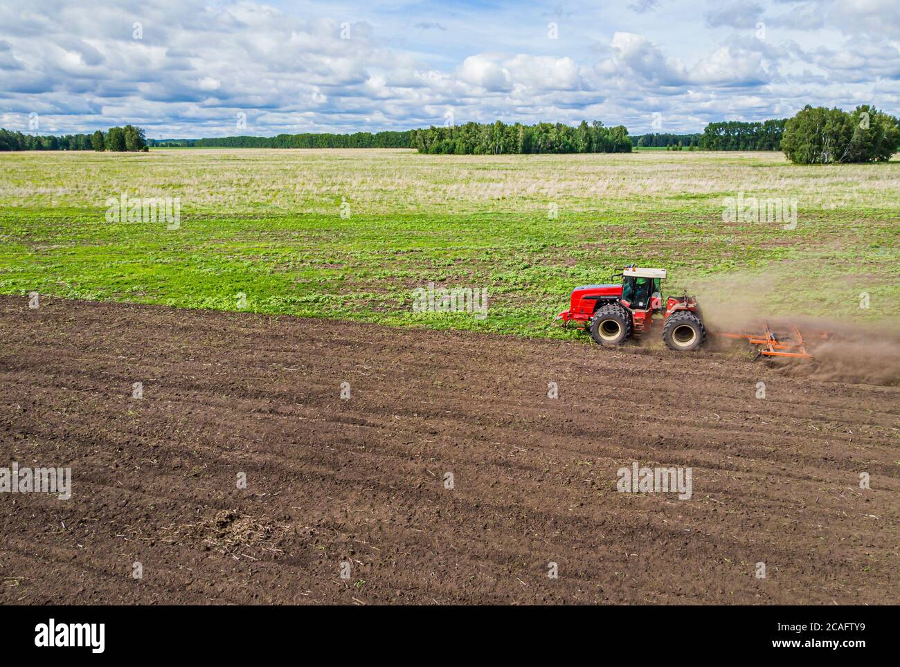 la grande macchina agricola coltiva il terreno. La vista dall'alto. Aratura terra per piantare crops. Foto dall'occhio dell'uccello vista con Foto Stock