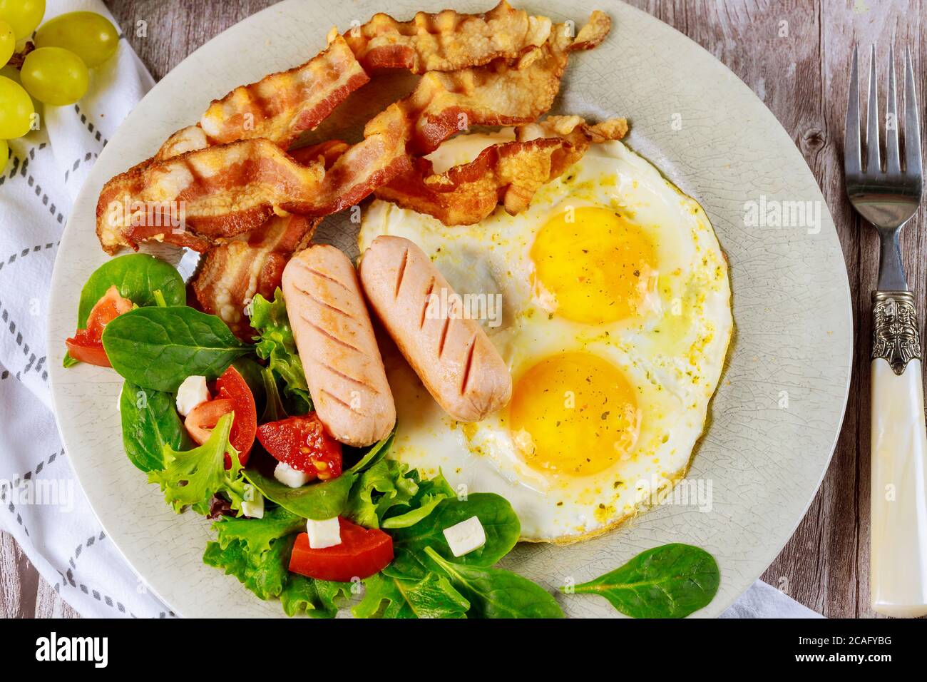 franche di pollo, uova fritte, pancetta e insalata per colazione. Foto Stock