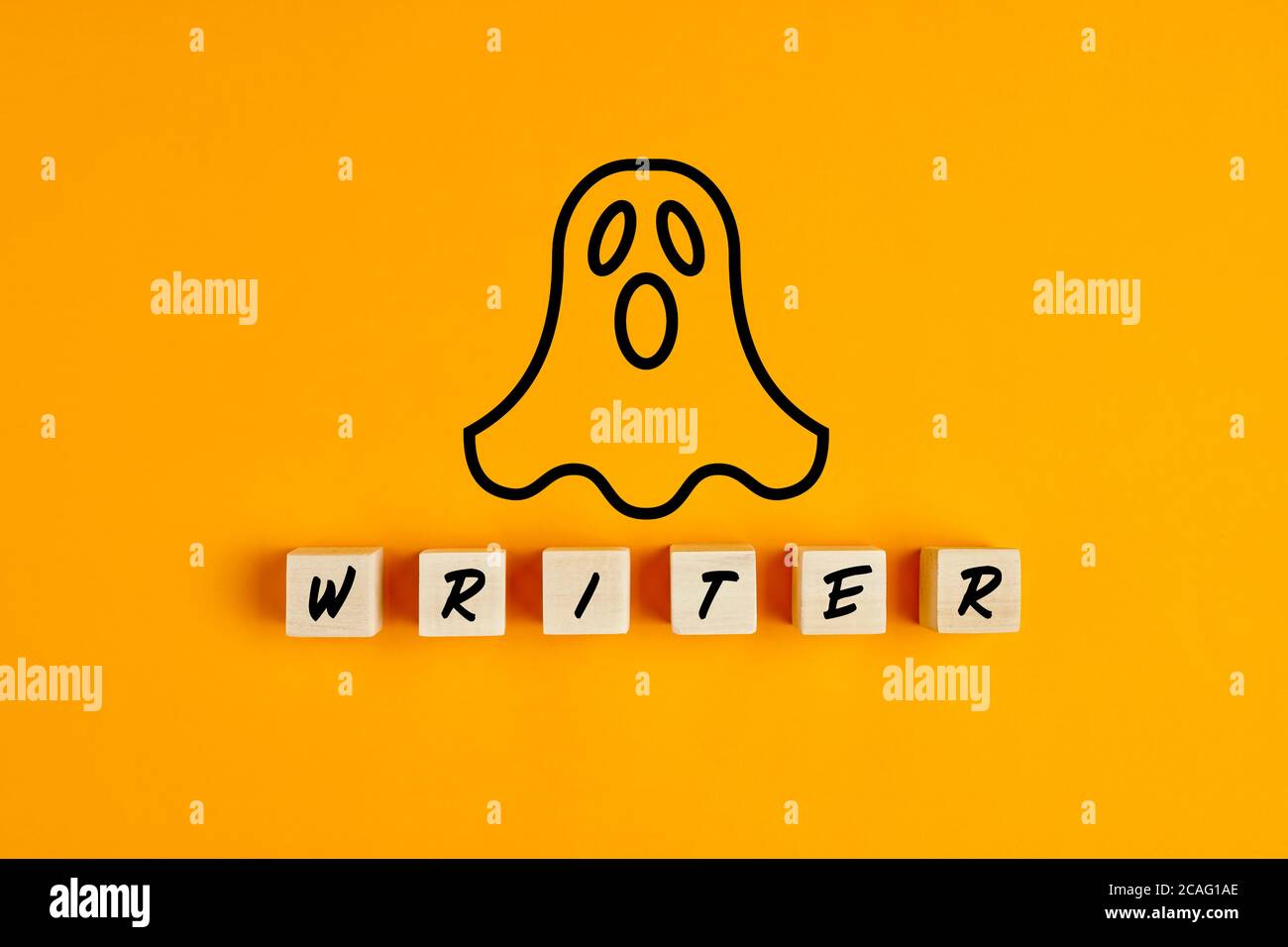Ghostwriter concetto con un simbolo fantasma e il word writer su blocchi di legno su sfondo giallo. Foto Stock
