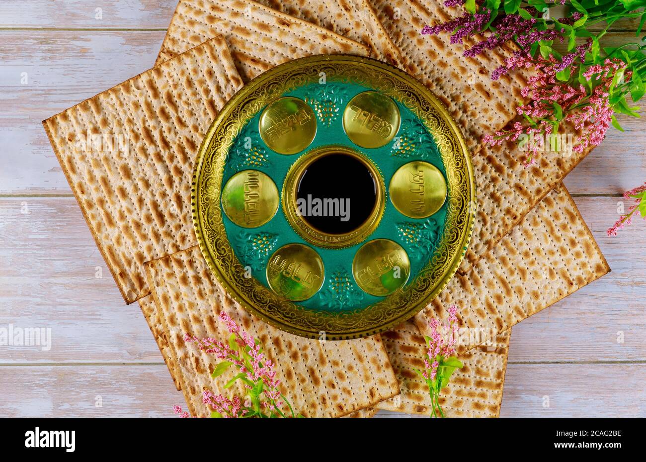 Matzah ebraico, capretto con vino e seder con testo in uovo ebraico, osso, erbe, karpas, chazeret e charoset. Concetto di passaggio. Foto Stock