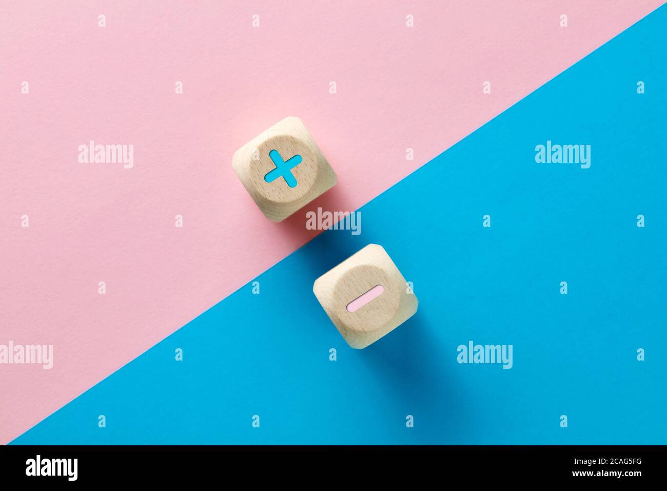 Unità o equilibrio del concetto di opposti. Icone negative e positive o più e meno su sfondo rosa e blu. Foto Stock