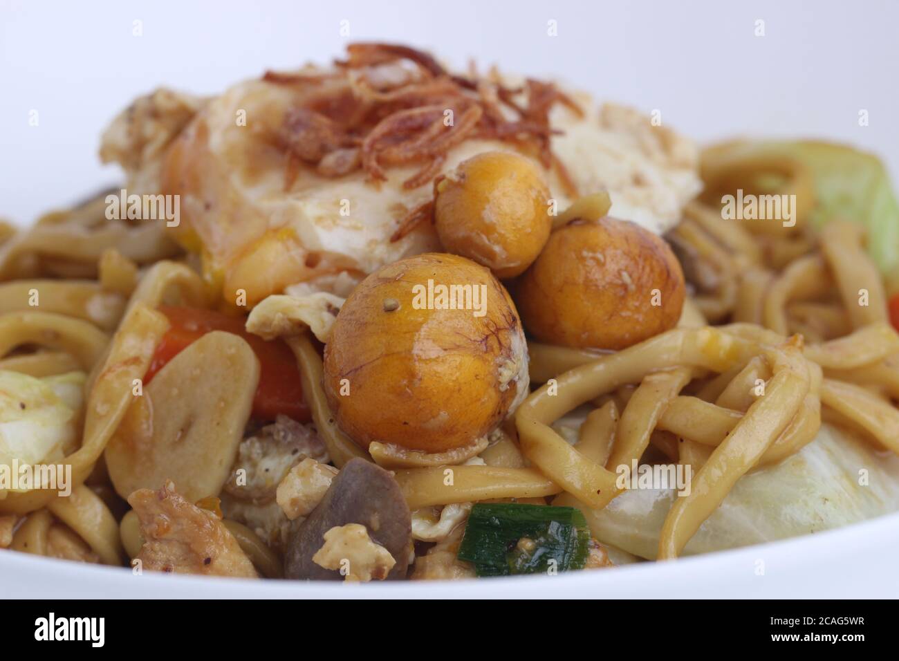 Bakmie Jawa Indonesian cibo di strada tradizionale fritto Noodle con uova di uritano isolato su sfondo bianco. Foto Stock