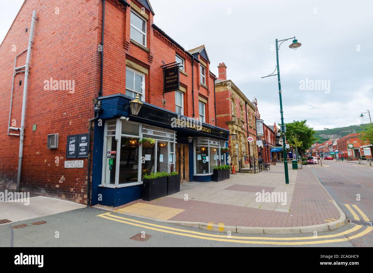 Prestatyn, Regno Unito: 06 luglio 2020: Una scena generale di strada di High Street alle prime ore della sera. La casa pubblica William Morgan è visibile in primo piano. Foto Stock