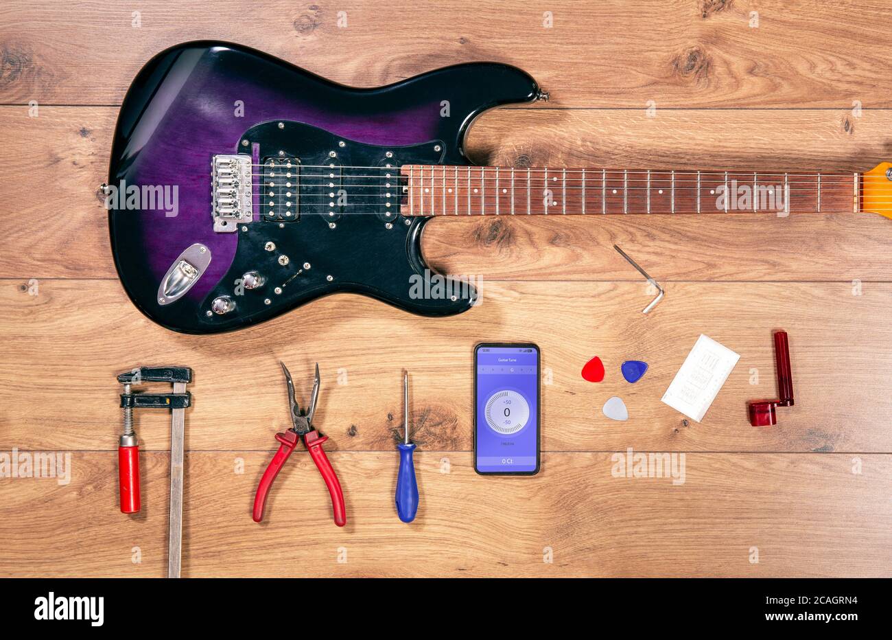 Vista dall'alto più lustra con chitarra elettrica e utensili. Scrivania artigianale in legno con vista piatta e chitarra elettrica jazz blues. Foto Stock